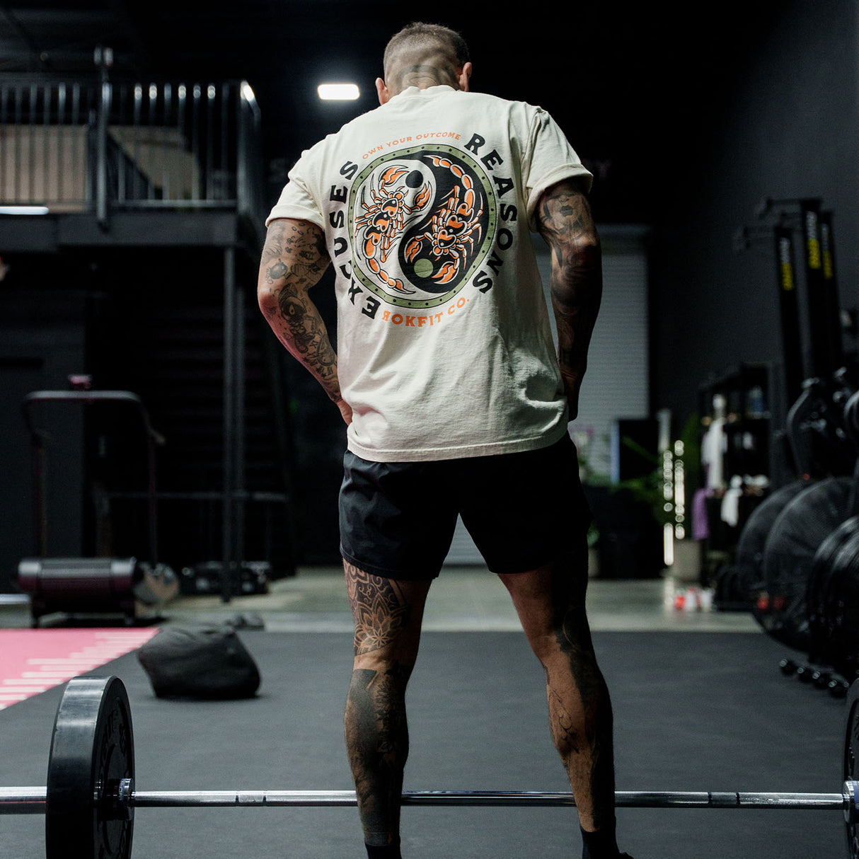 Male model in a gym wearing Street Tee with 'Excuses or Reasons' graphic